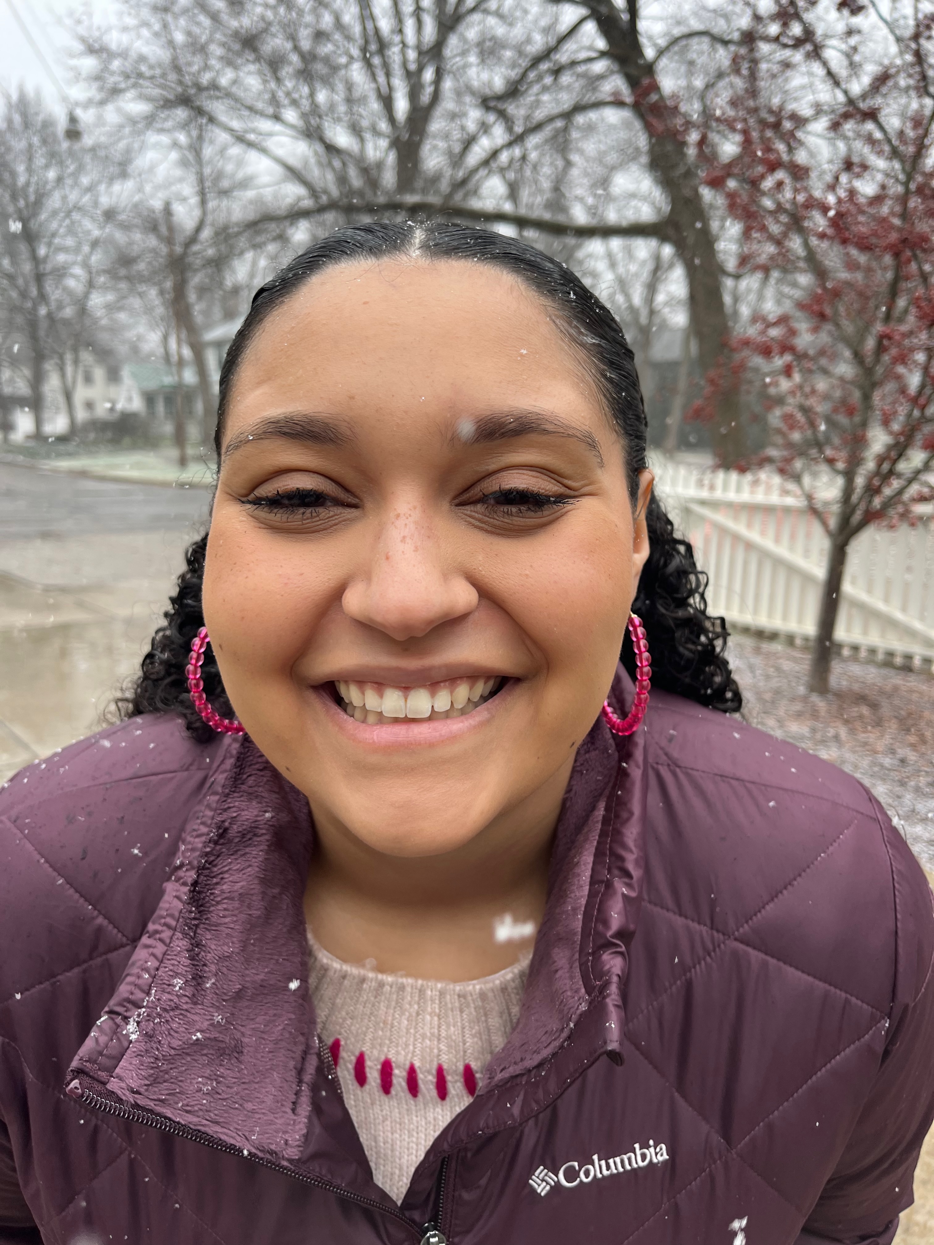 Zoë smiling while standing in the snow